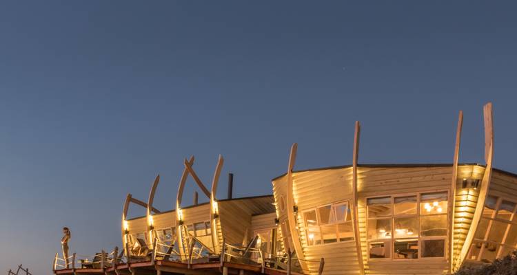 Einzigartige Wüstenunterkunft in der Abenddämmerung mit Sternenhimmel.