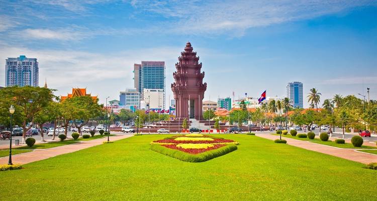 Grote open openbare ruimte met monument en stadsgezicht op de achtergrond.