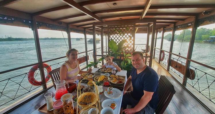 Familia disfrutando de una comida en un barco.