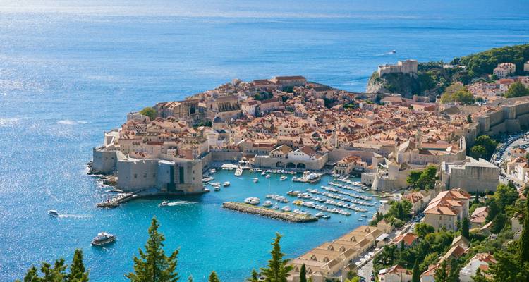 Vue classique de carte postale depuis le Mont Srđ surplombant la vieille ville de Dubrovnik entourée par une mer d'un bleu éclatant.