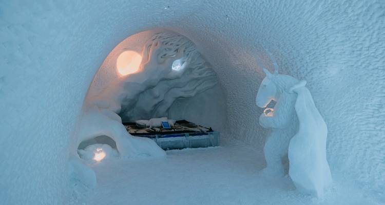 Chambre à l'intérieur d'un hôtel de glace avec des décorations sculptées dans la glace.