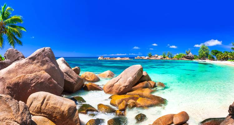 Seychelles beach with blue sky and turquoise water.