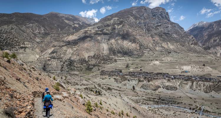 Wanderer auf einem Wanderweg mit weiter Bergaussicht.