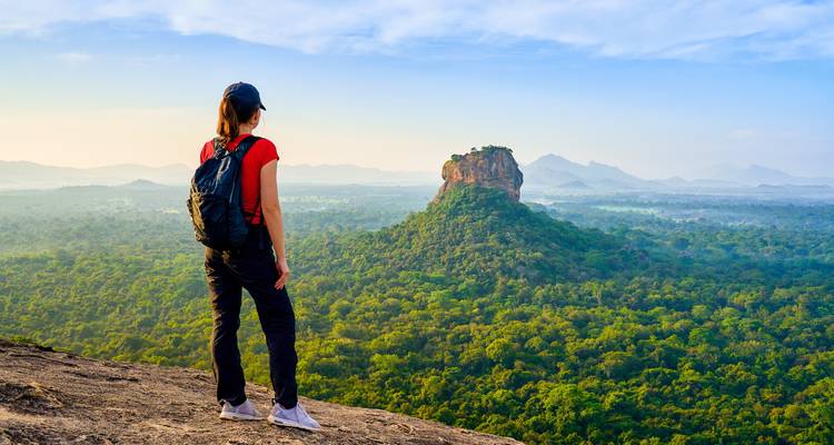 Wanderer auf einem Berggipfel mit Panoramablick auf den Sigiriya-Felsen.