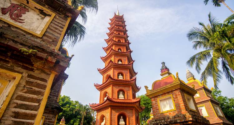 Hohe Pagode umgeben von Palmen.