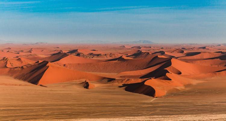 Luchtfoto van uitgestrekte zandduinen.