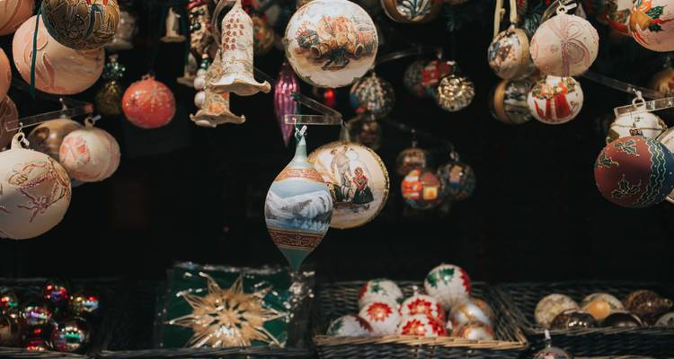 Gros plan sur les décor de Noël faits à la main et les boules de Noël accrochées à un étal de marché.
