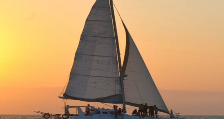 Silhouet van een zeilboot tegen een zonsonderganglucht.