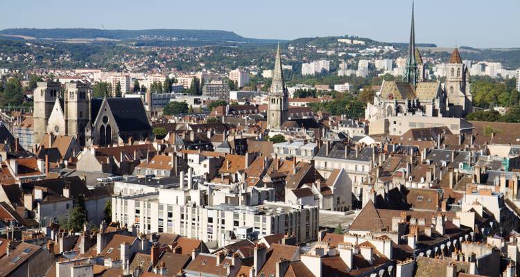 Vue panoramique depuis le toit sur les maisons aux tuiles de terre cuite de Dijon, les clochers d'églises et les collines environnantes.