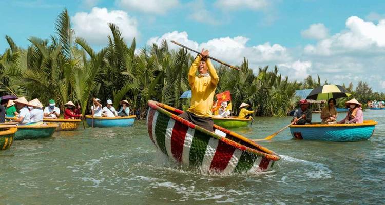 Touristen in bunten runden Booten auf einem Fluss, umgeben von Palmen.