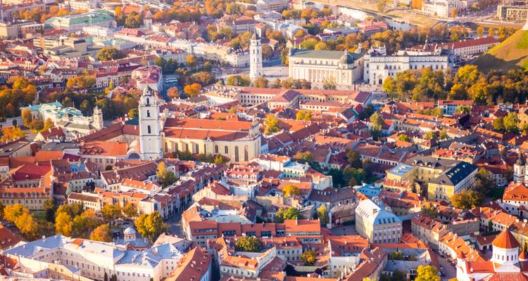 Vibrant aerial of Vilnius old town with red-tiled roofs, church towers and autumn trees