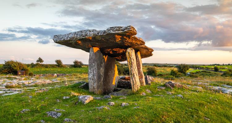 Antikes Poulnabrone-Dolmen, das auf einer grasbewachsenen Kalksteinebene zur goldenen Stunde steht