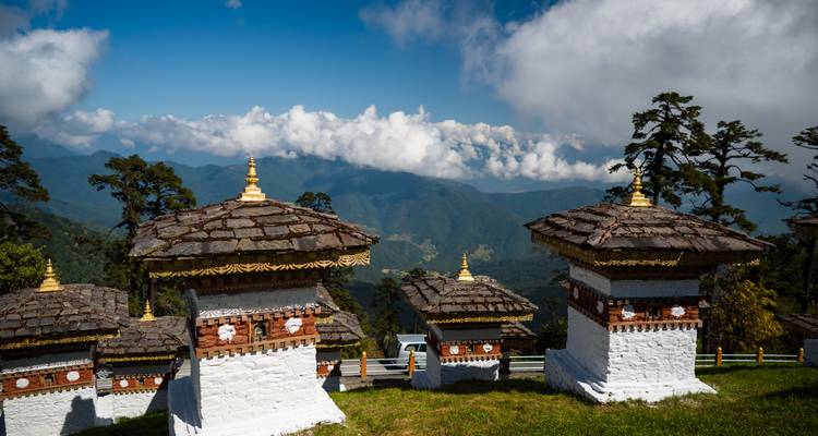 Rij traditionele stupa's met uitzicht op een uitgestrekte vallei.