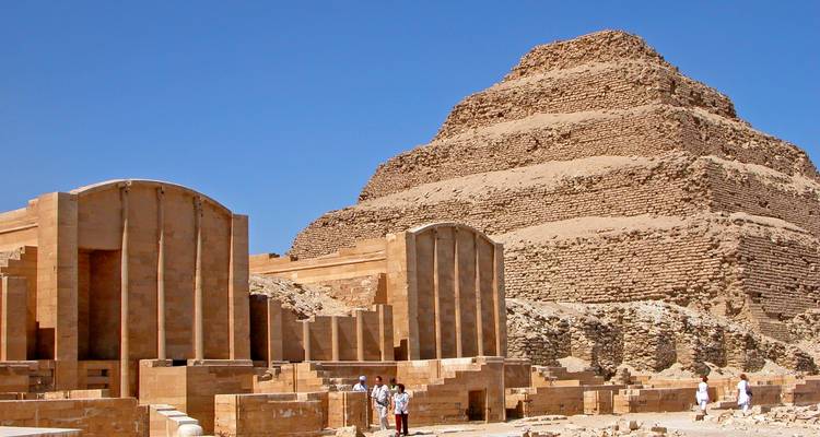 Ruins of an ancient pyramid with tourists.