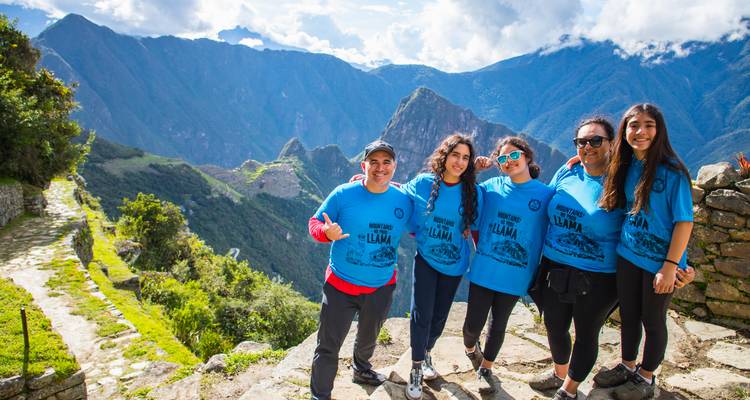 Gruppe von Menschen, die auf einem malerischen Wanderweg mit Bergen posieren.
