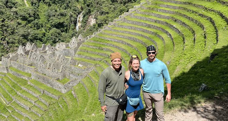 Touristen, die vor Inka-Terrassen posieren.