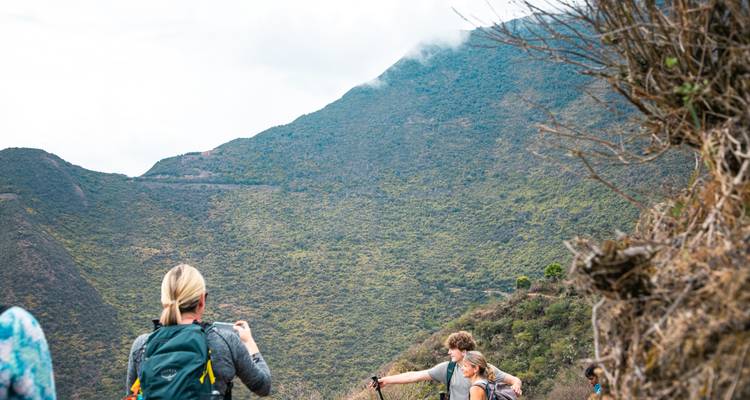 Des randonneurs prenant des photos sur un sentier de montagne.