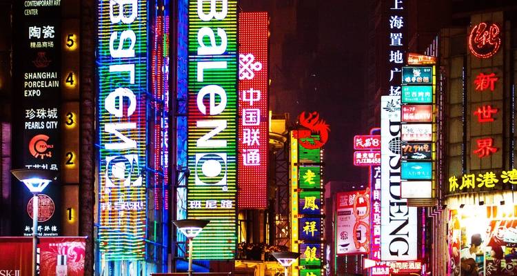 Bright neon signs in a bustling urban area at night.