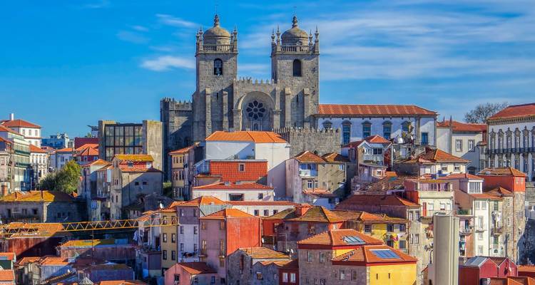 Colorful houses around an ancient cathedral in a cityscape.