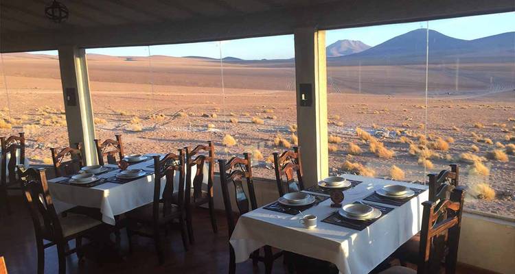 Essbereich mit großen Fenstern mit Blick auf eine Wüstenlandschaft