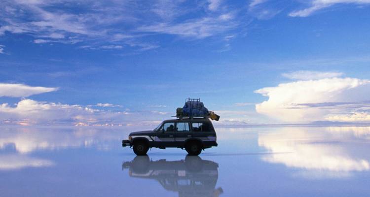 SUV auf der spiegelnden Wasseroberfläche des Uyuni-Salzsees