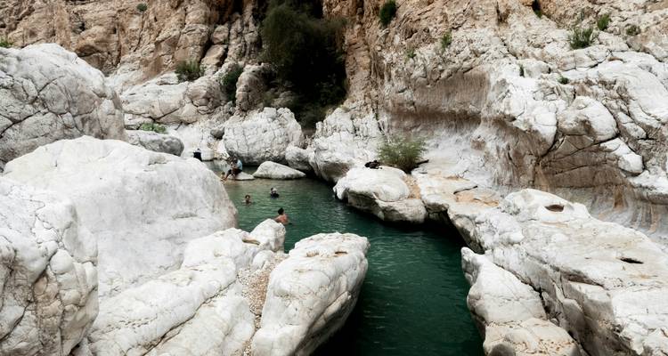 Los nadadores disfrutan de una piscina angosta de color esmeralda rodeada de imponentes paredes de cañón de mármol blanco.