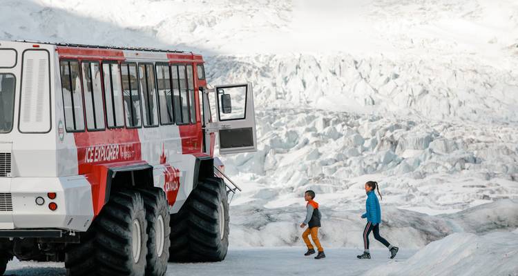 Véhicule Ice Explorer sur glacier avec paysage enneigé.