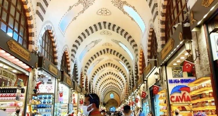 Busy interior of a market with intricate ceiling design.