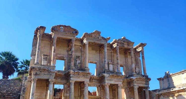 Ancient library ruins under clear blue sky.