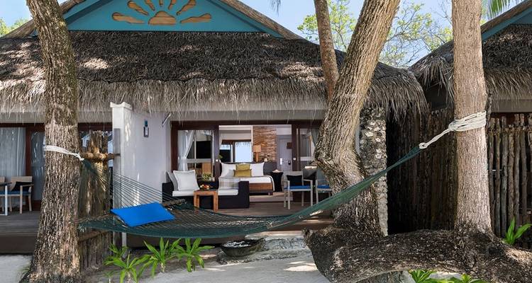 A hammock in front of beach villas.