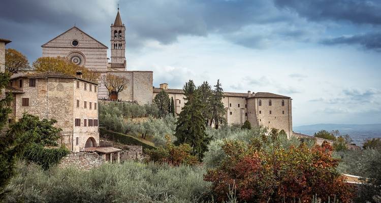 Eine Bergkuppe-Kirche und Altstadt inmitten von Grün und bewölktem Himmel.