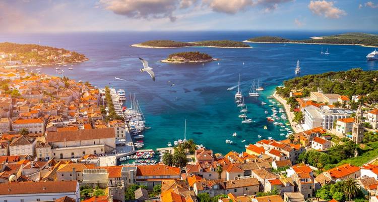 Luftaufnahme einer Küstenstadt mit leuchtend blauen Gewässern.