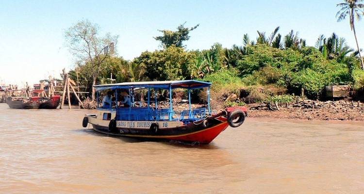 Ein Passagierboot auf einem Fluss inmitten von Grün.