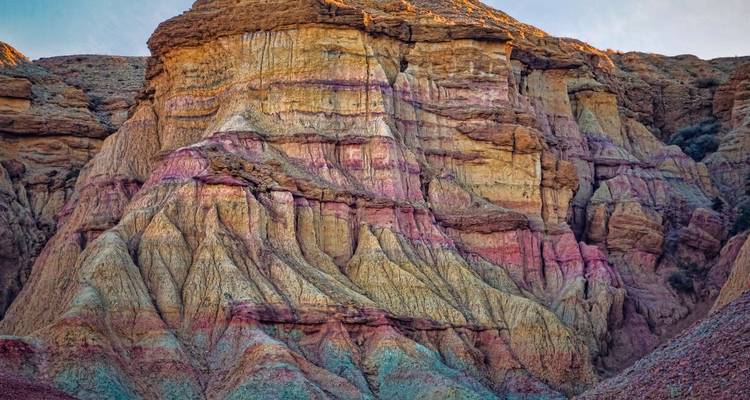 Formaciones rocosas estratificadas y coloridas en un paisaje desértico.