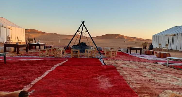Outdoor seating area in a desert setting with surrounding tents.
