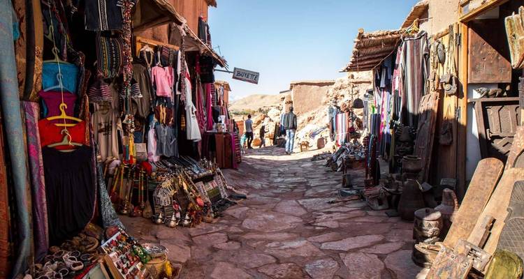 Bustling market street lined with shops and colorful goods.