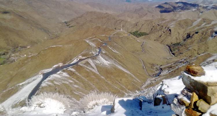 Carretera de paso de montaña con una ligera capa de nieve.