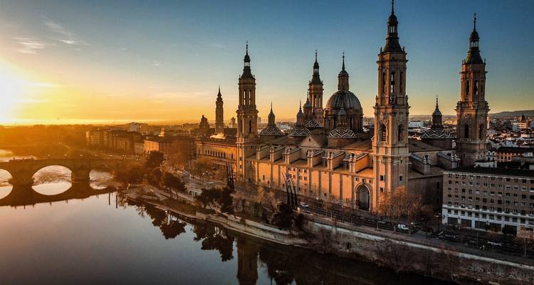 Basilica del Pilar in Zaragoza at sunset reflecting in the river.
