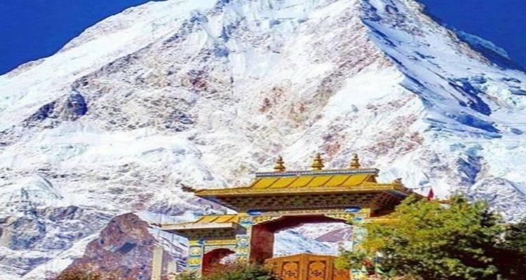 Versierde poort met besneeuwde berg op de achtergrond.