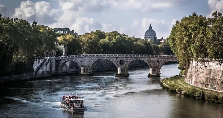 Brücke über einen Fluss mit Blick auf ein Kuppelgebäude in der Ferne.