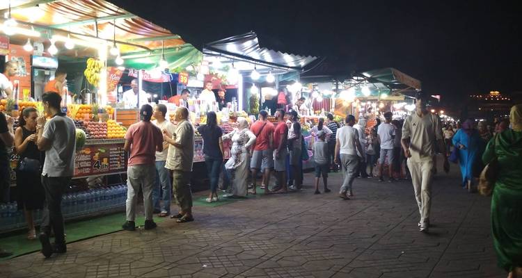 Mensen die 's avonds een levendige straatmarkt verkennen.