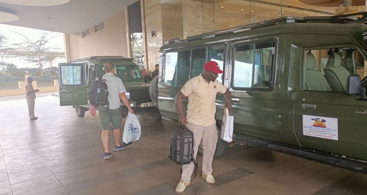 Mensen die zich voorbereiden op een safari bij voertuigen.