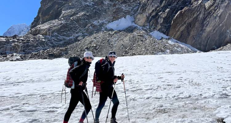 Wandelaars uitgerust voor sneeuw, lopend in een bergachtig besneeuwd gebied.