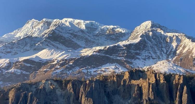 Une chaîne de montagnes avec de la neige sur les sommets sous un ciel dégagé.