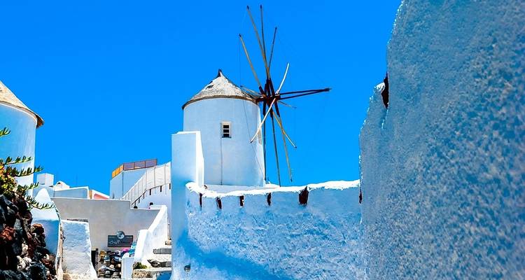 Traditionelle griechische Windmühlen vor einem strahlend blauen Himmel.