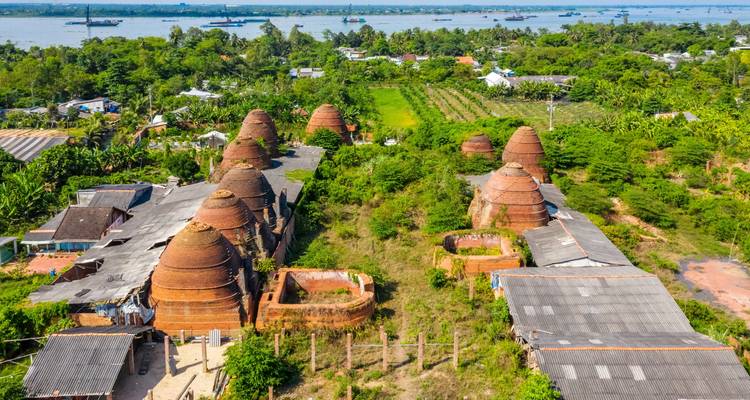 Luchtfoto van ronde bakstenen ovens omringd door groene velden.