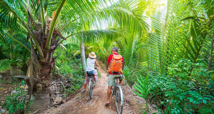 Twee mensen die fietsen door een weelderig groen junglepad.
