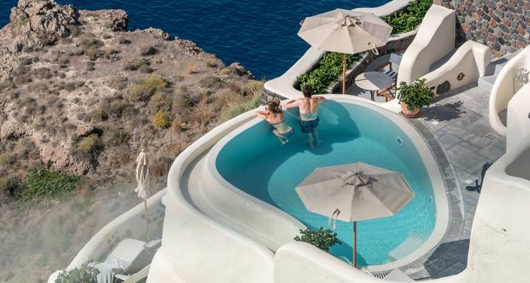 Luxury pool overlooking the sea with two people relaxing.