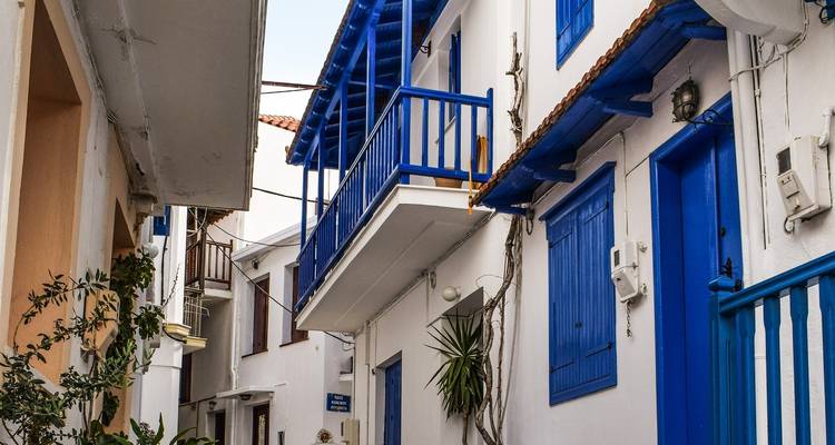 Smalle straat met helderblauwe en witte huizen.