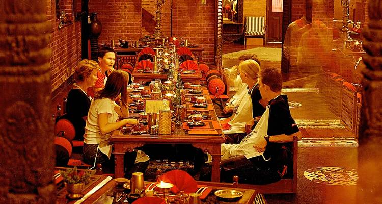 Group of people dining at a restaurant with brick interior.